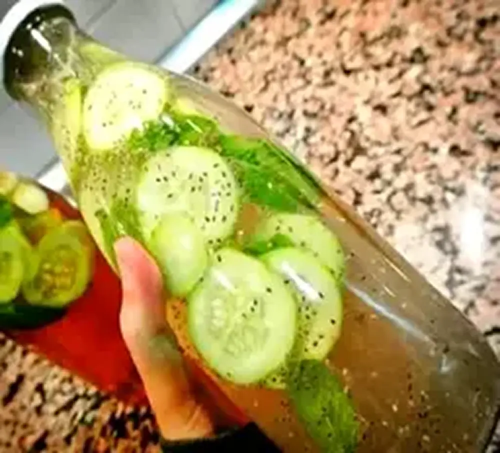 Vidro transparente com rodelas de pepino e ervas em conserva